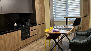 Кухня в сдержанных теплых оттенках в сочетании с текстурой дерева на мебельных фасадах
